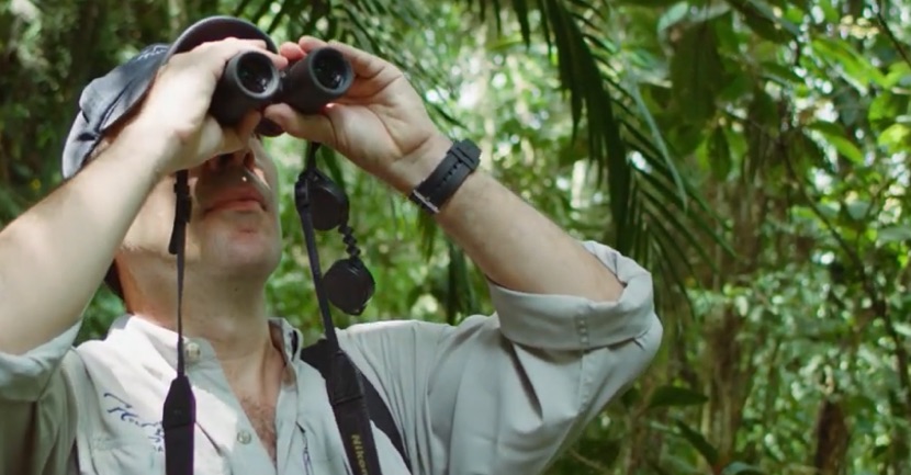 Esteban Payán, Director Regional para América del Sur ISA observando el cielo a través de unos binoculares, en medio de la selva