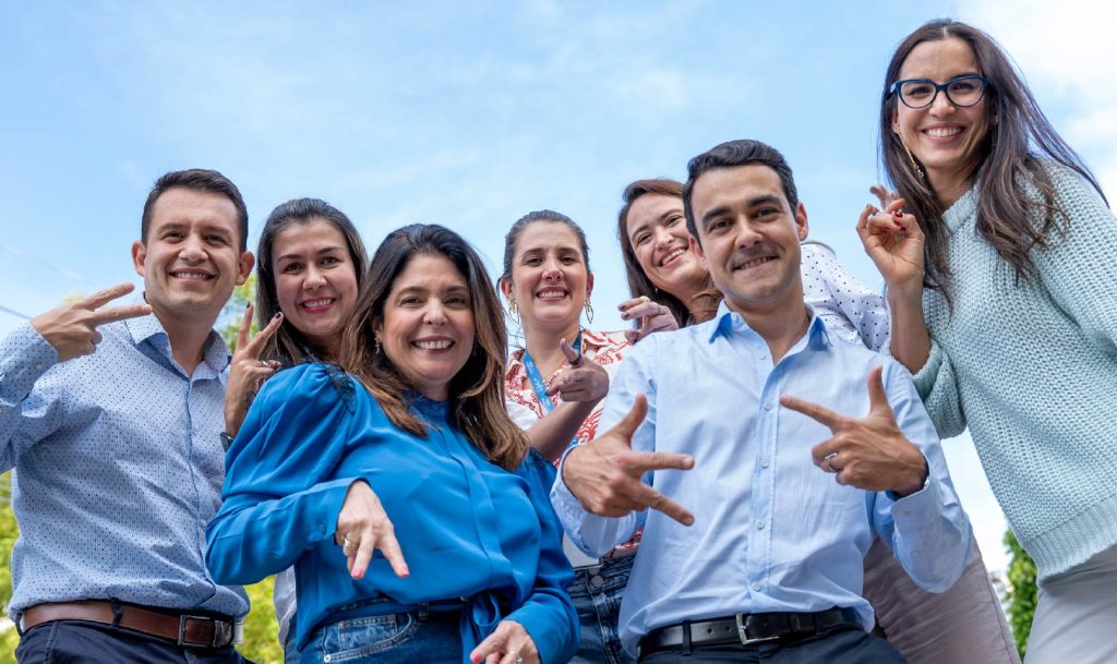 Empleados de ISA sonriendo. Hay un cielo azul
